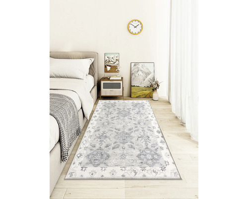 Dekoratives Wohnzimmer mit gemustertem Teppich unter einem Bett.