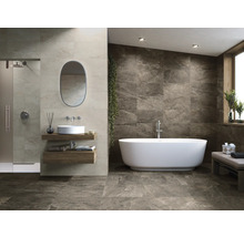 Badezimmer mit Dusche, Waschbecken, Spiegel und freistehender Badewanne vor einer gefliesten Wand.