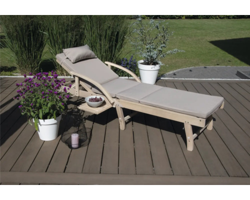 Holzliege mit Auflage, Seitentisch und Dekoration im Garten