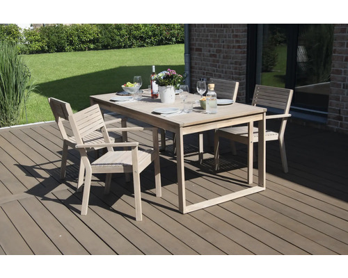 Gartenszene mit Esstischgruppe aus Holz auf einer Terrasse