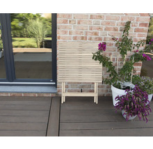 Klapptisch aus Holz auf einer Terrasse neben Pflanzen
