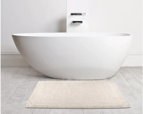 Freistehende Badewanne mit Badteppich im Badezimmer.