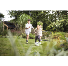 Kinder spielen Fußball im Garten mit Fußballtor