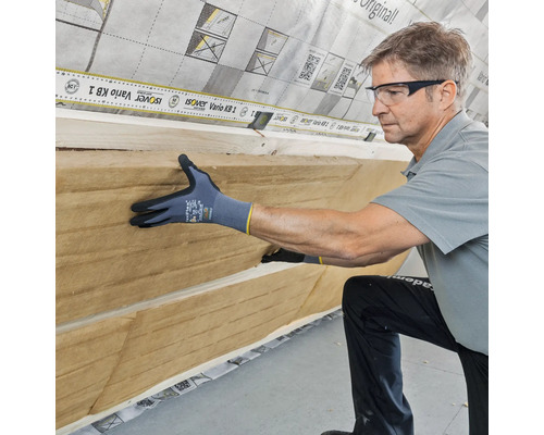 Handwerker bei der Installation von Dämmmaterial an einer Wand