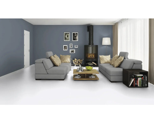 Wohnzimmer mit grauer Couchgarnitur, Kaminofen, Holztisch und Dekorationen für eine gemütliche Atmosphäre.