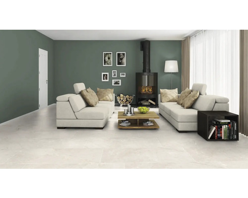 Wohnzimmer mit Sitzgruppe, Kaminofen, Couchtisch und keramischen Bodenfliesen.