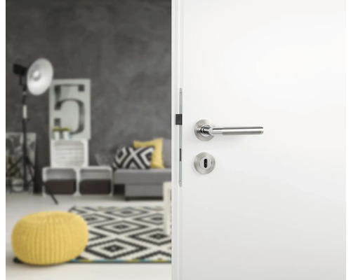 Weiße Zimmertür mit silberfarbener Türklinke in einem modern eingerichteten Raum.