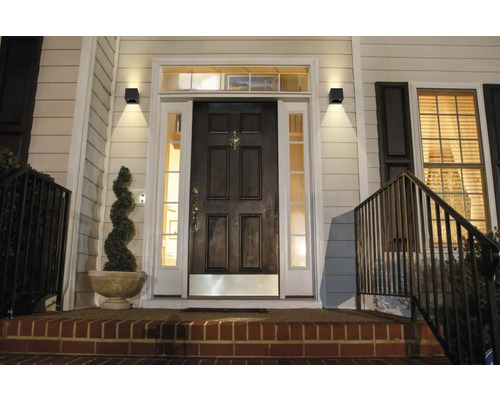 Eingangsbereich eines Hauses mit beleuchteten Außenwandleuchten