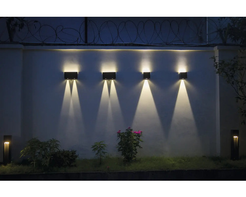 Beleuchtete Gartenmauer mit mehreren Wandleuchten für den Außenbereich