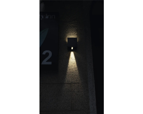 Quadratische Wandleuchte für den Außenbereich strahlt Licht nach unten.