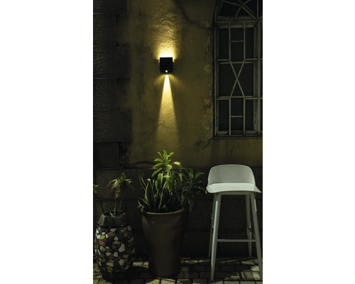 Szene mit Außenwandleuchte, Blumentöpfen und Stuhl im Garten