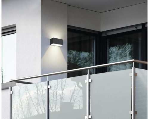 Moderne Außenwandleuchte an einem Balkon mit Edelstahlgeländer und Milchglas