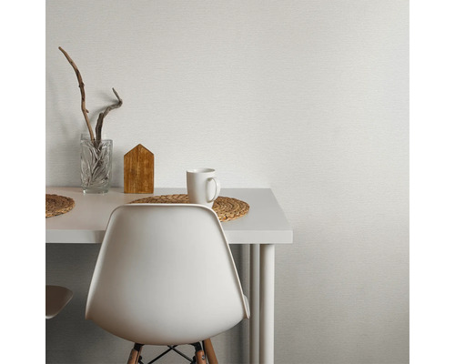 Nahaufnahme eines Tisches mit Dekorationsgegenständen und einer weißen Wandtapete mit Textur