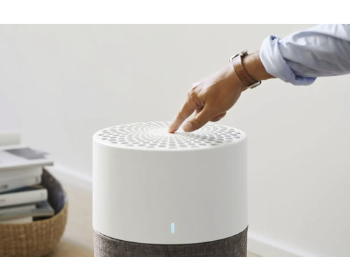 Finger berührt Luftreiniger zur Bedienung