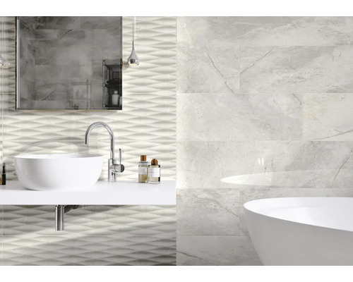 Badezimmer mit Waschbecken, Spiegel, Badewanne und Wandfliesen mit Marmoroptik und Wellenmuster