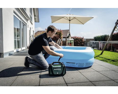 Mann pumpt auf der Terrasse einen aufblasbaren Pool mit einer Metabo Akku-Luftpumpe auf.