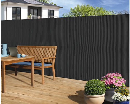 Gartenszene mit Sichtschutzzaun, Holztisch und Sitzbank