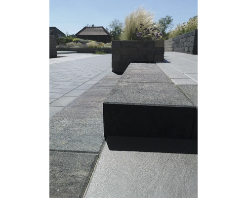 Gartenanlage mit Pflastersteinen und Mauerelementen