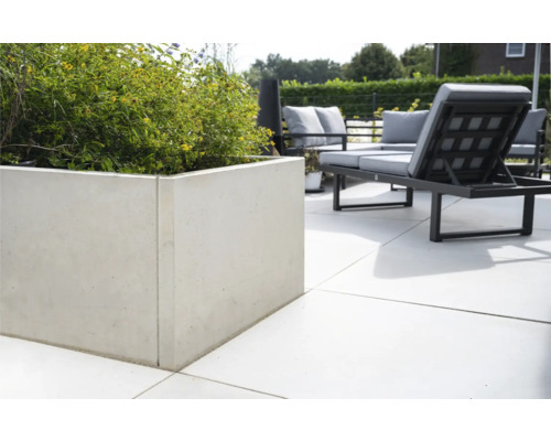 Beton-Pflanzgefäß mit Bepflanzung auf einer Terrasse mit Gartenmöbeln