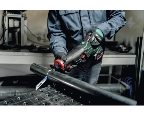 Eine Person schneidet ein Metallrohr mit einer Metabo Säbelsäge.