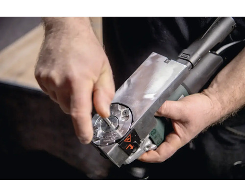 Eine Person justiert eine Kantenfräsmaschine.