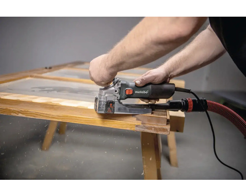 Mann arbeitet mit einer Metabo Nutfräse an einem Holzrahmen.