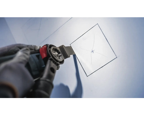 Oszillierendes Multifunktionswerkzeug beim Schneiden einer quadratischen Öffnung in eine Wand.