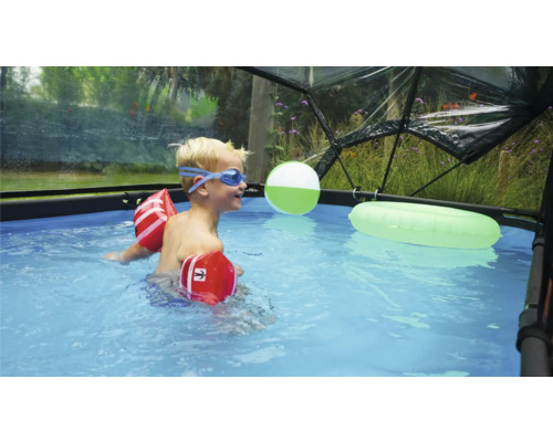 Kind mit Schwimmflügeln und Schwimmbrille in einem Pool unter einer Poolkuppel