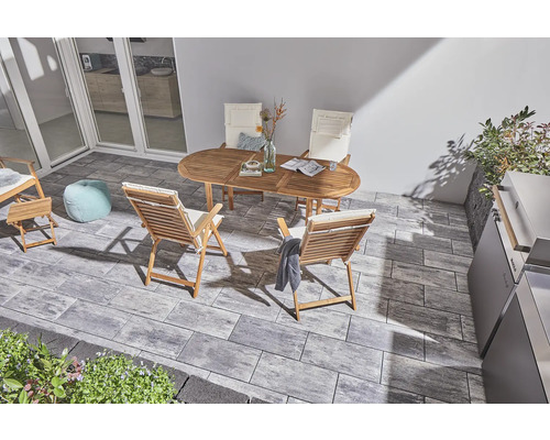 Terrasse mit grauen Betonpflastersteinen, Holztisch und Stühlen