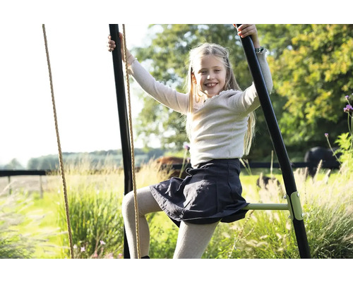 Mädchen klettert auf Gartenschaukel für Kinder