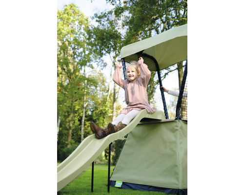 Mädchen rutscht auf einer EXIT Aksent Spielturm Rutsche im Garten