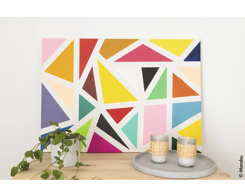 Dekoratives Gemälde mit geometrischen Formen, Zimmerpflanze und Kerzen auf einem Tisch