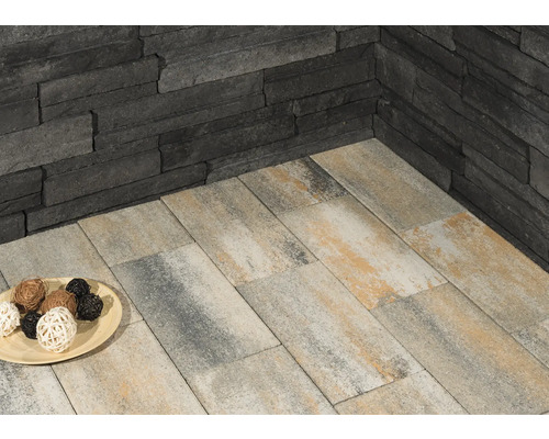 Wandverkleidung aus Stein und Bodenplatten im Außenbereich.