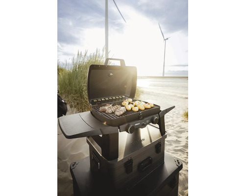 Tragbarer Gasgrill mit Fleisch und Kartoffeln am Strand