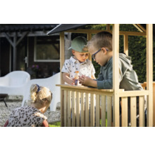 Drei Kinder spielen in einem Spielhaus aus Holz im Garten.