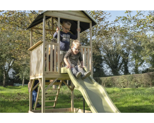 Spielturm mit Rutsche im Garten mit spielenden Kindern.