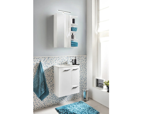 Modernes Badezimmer mit weißem Waschtischunterschrank, Spiegelschrank und blau gemusterter Badematte