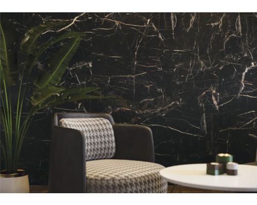 Wohnzimmer mit schwarzer Marmorwand, Sessel und Tisch