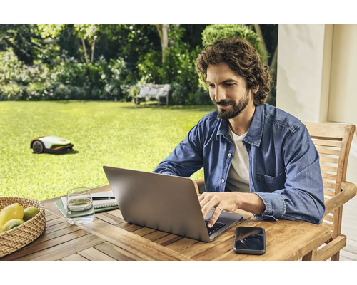 "Mann arbeitet am Laptop im Garten