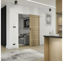 Innenraumansicht mit Holzschiebetür, Wohnzimmer und Küchendetails.