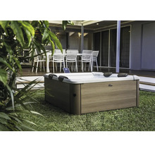 Outdoor Whirlpool auf Rasen vor Terrasse mit Gartenmöbeln