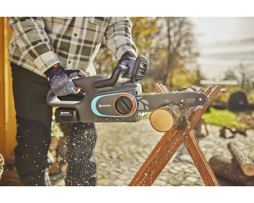 Person sägt Holz mit einer Gardena Akku-Kettensäge auf einem Holzsägebock