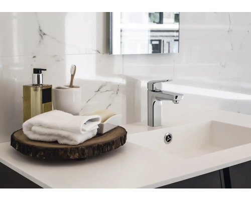 Helles Badezimmer mit Waschbecken, Armatur und Badaccessoires