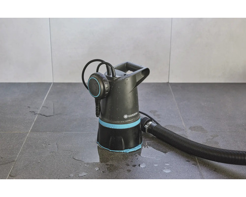 Gartenpumpe mit Schlauch auf Fliesenboden