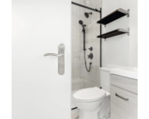 Teilansicht eines Badezimmers mit Toilette, Waschbecken, Dusche und einem Türgriff an einer weißen Tür