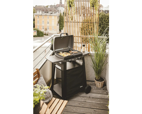 Gasgrill auf einem Balkon mit Grillgut und Pflanzen
