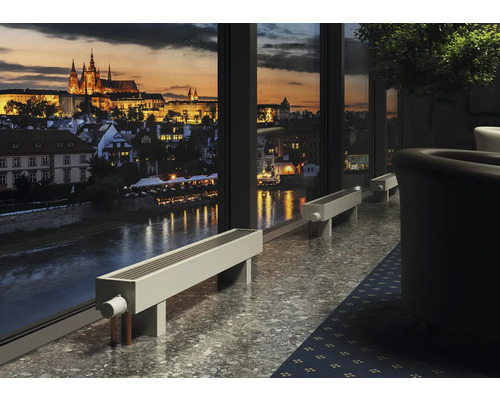 Innenraum mit Heizkörpern vor einem großen Fenster mit Blick auf die Stadt bei Nacht