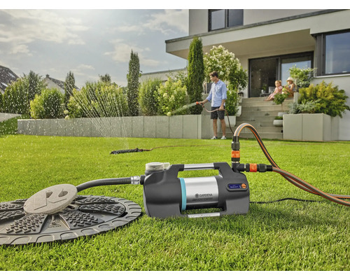 Garten mit Bewässerungssystem und Haus im Hintergrund