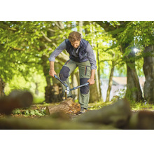 Mann spaltet Holz mit einer Astschere im Freien