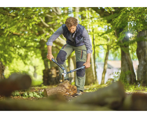 Mann spaltet Holz mit einer Astschere im Freien